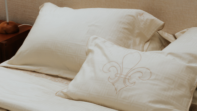 Cama bege cashmere combinada com almofadas neutras