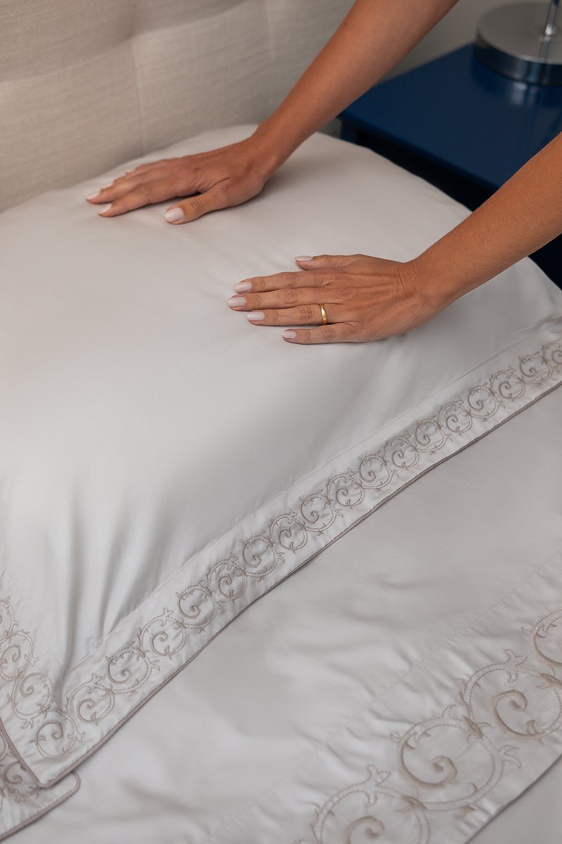 Cama branca com almofadas neutras