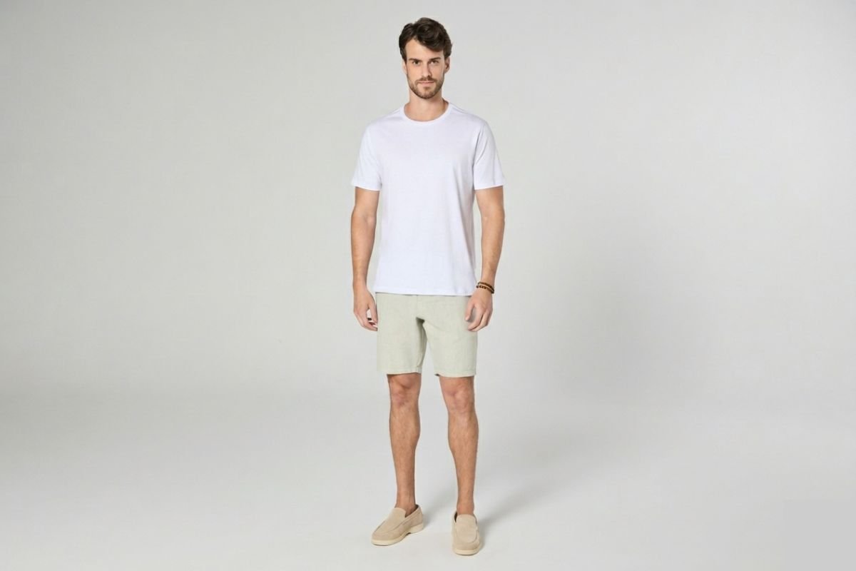 modelo usando bermuda shino bege e camiseta branca em fundo cinza