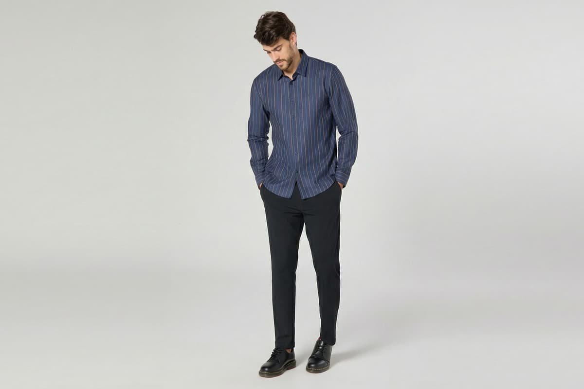 modelo usando cal&ccedil;a preta e camisa azul escuro