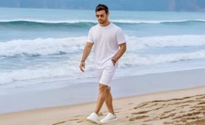 homem caminhando na praia com camiseta branca e bermuda clara homem caminhando na praia com camiseta branca e bermuda clara
