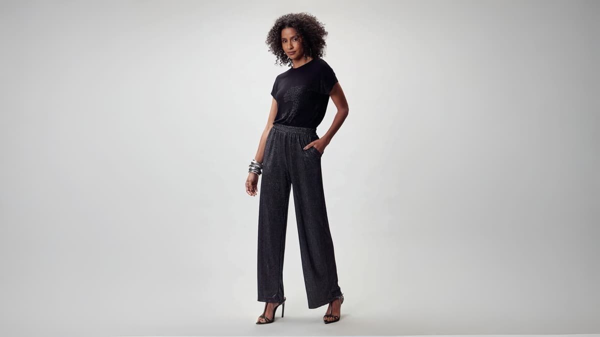 modelo usando calca pantalona e blusa preta